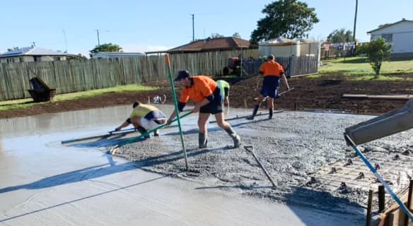 Workers applying new concrete in a backyard — Concreting Services Dalby, QLD